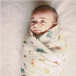 Swaddle is a light, breathable muslin wrap that mimics the feeling of being in the womb for a baby. It helps them feel safe and secure while they rest or sleep. Organic cotton organic muslin premium gift luxury gift sustainable clothes baby clothes baby gift newborn gift birthday gift onesie bodysuit